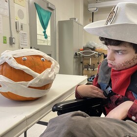 un élève à l'halloween déguisé en cowboy avec une citrouille